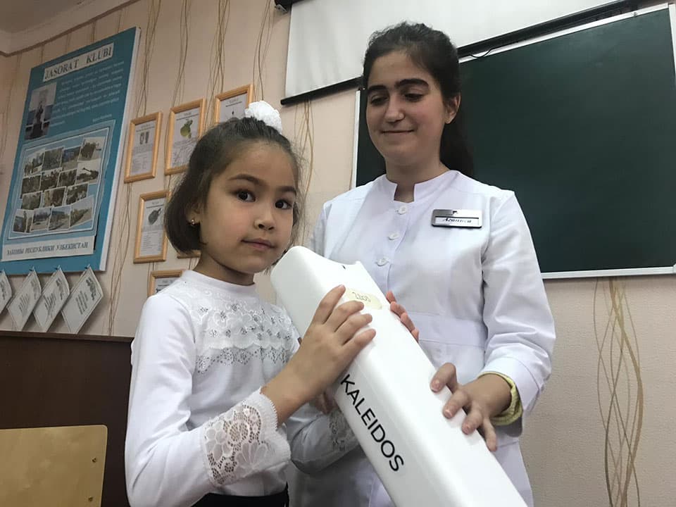 A child undergoing vision screening with an Adaptica Kaleidos / 2WIN-S device during a school campaign in Uzbekistan