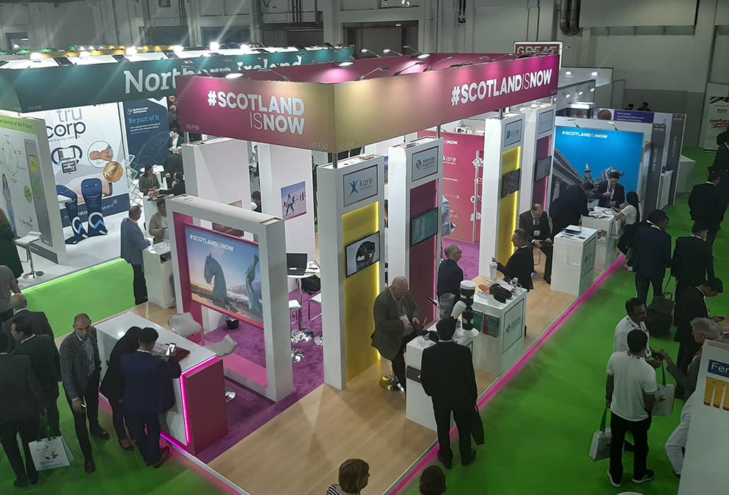 Aerial view of the company exhibition booth at the Arab Health trade show, featuring branding and product display areas.