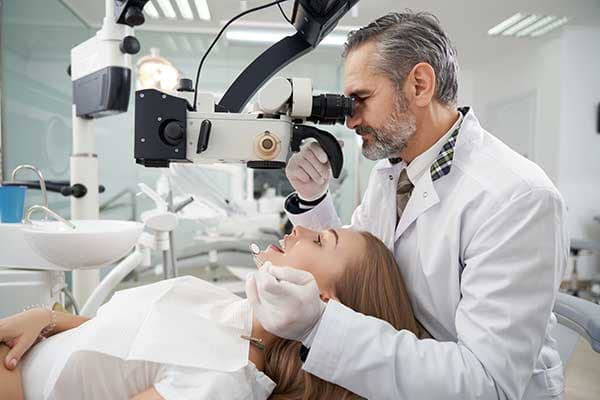Dental professional using the OpLight device to provide focused illumination during a surgical procedure on a patient.