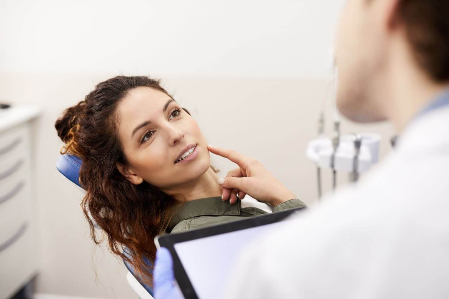 Clinician consulting with a patient in a clinical setting while reviewing data on a tablet device.
