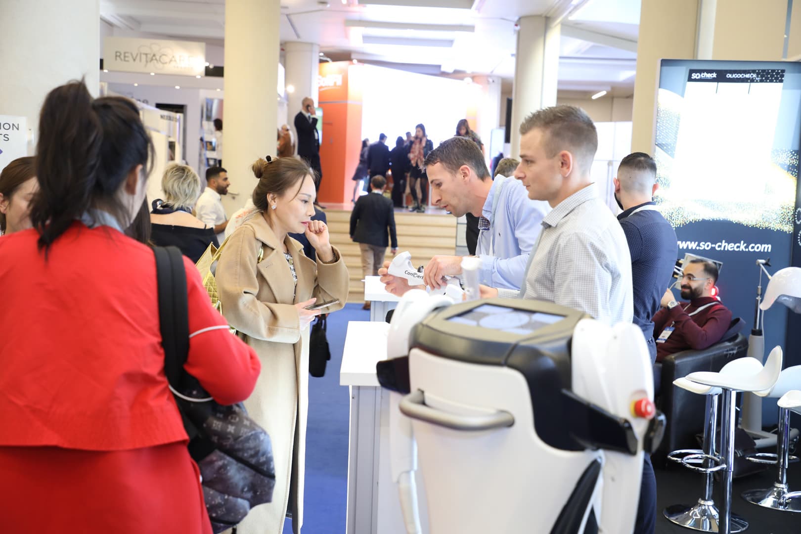 AAMS team members interacting with visitors at a trade show booth, showcasing medical equipment and displays.