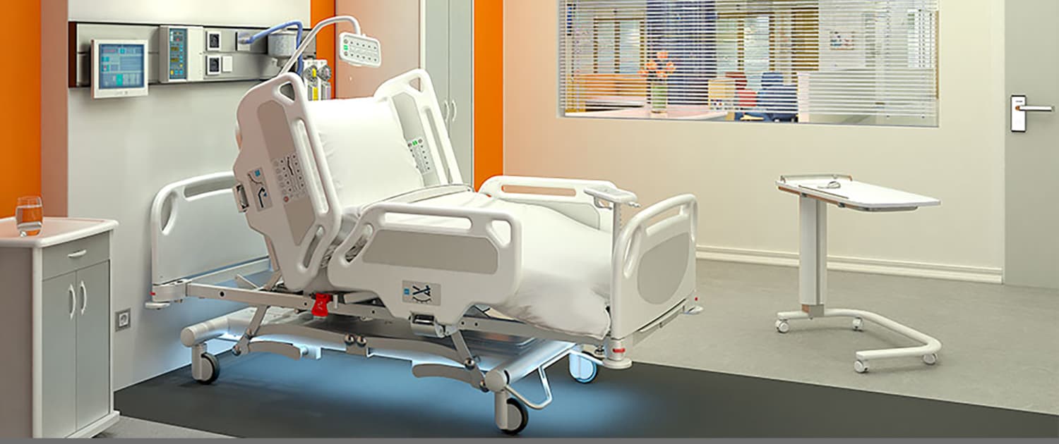 Professional medical room environment featuring an AHF hospital bed and bedside furniture for patient care.