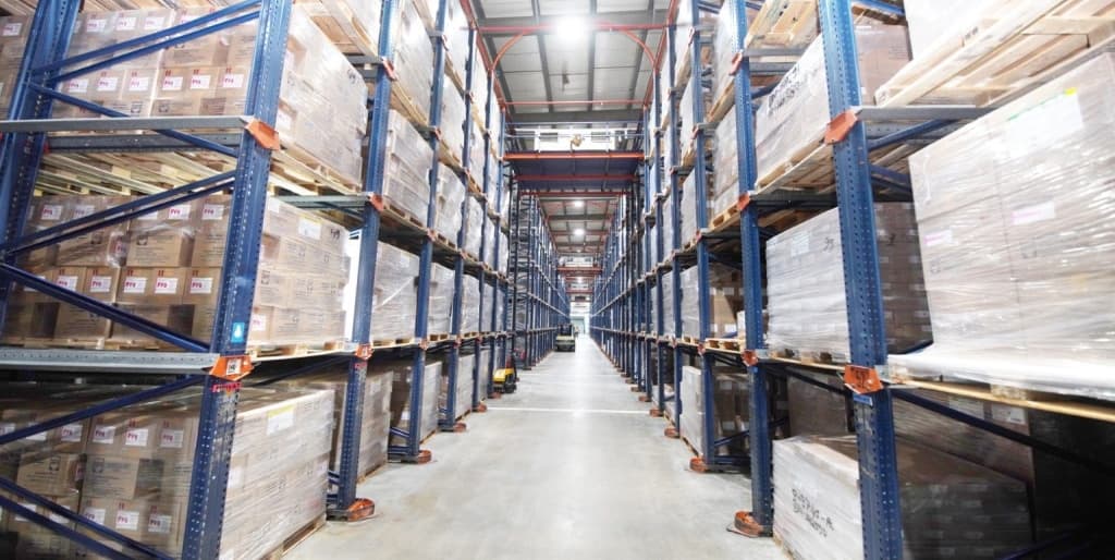 High-density warehouse storage facility featuring industrial racking systems filled with palletized pharmaceutical products.