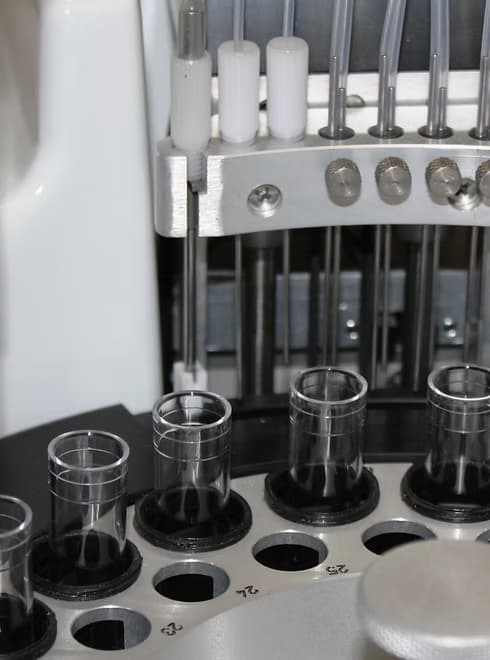 Close-up of an automated analyzer sample carousel with test tubes during the diagnostic process.