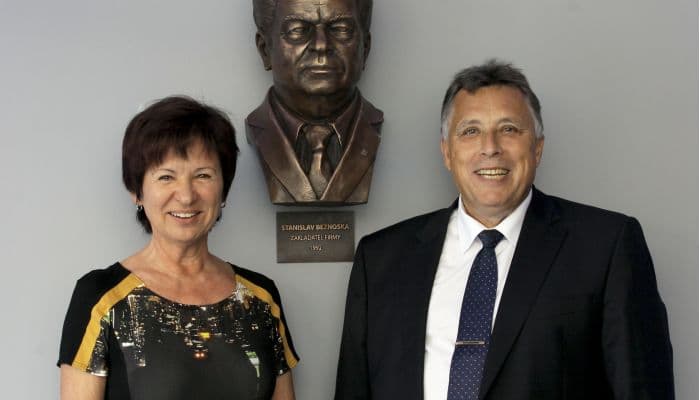 Company leadership standing in front of the commemorative bust of founder Stanislav Beznoska.