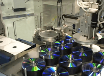 Automated production line featuring multiple diagnostic cartridges being processed on a high-speed manufacturing assembly system.
