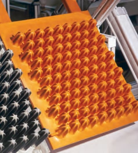 Industrial manufacturing view showing multiple molded foam components in a production lineup.