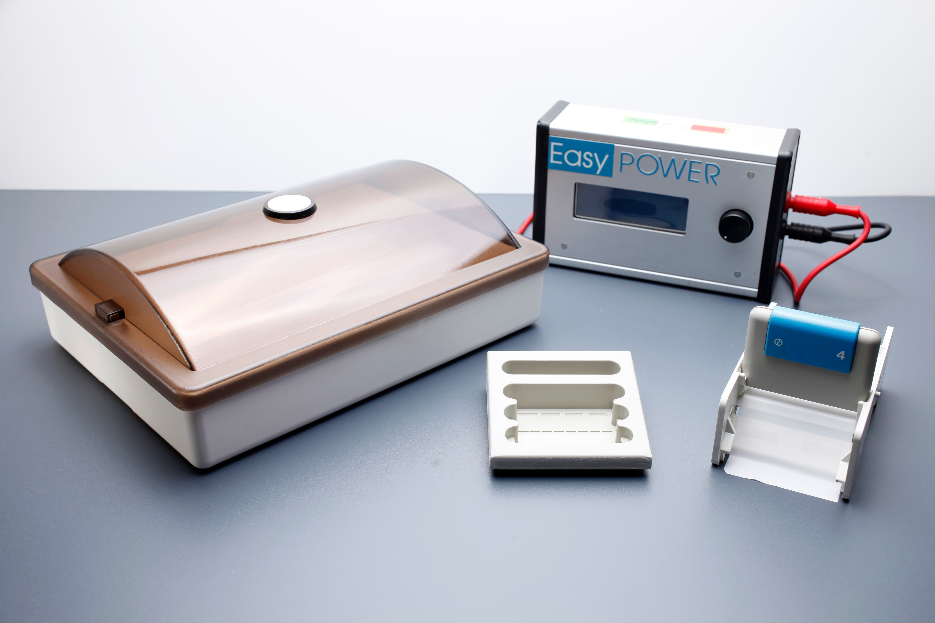 A laboratory kit featuring an Easy Power control unit, a covered incubation chamber, a sample tray, and a small plastic component.