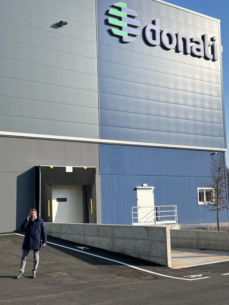 Exterior view of the Coremec Srl facility building with loading dock and company branding signage.