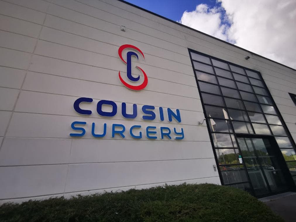 Exterior view of the Cousin Surgery corporate facility featuring the company logo and branding signage.