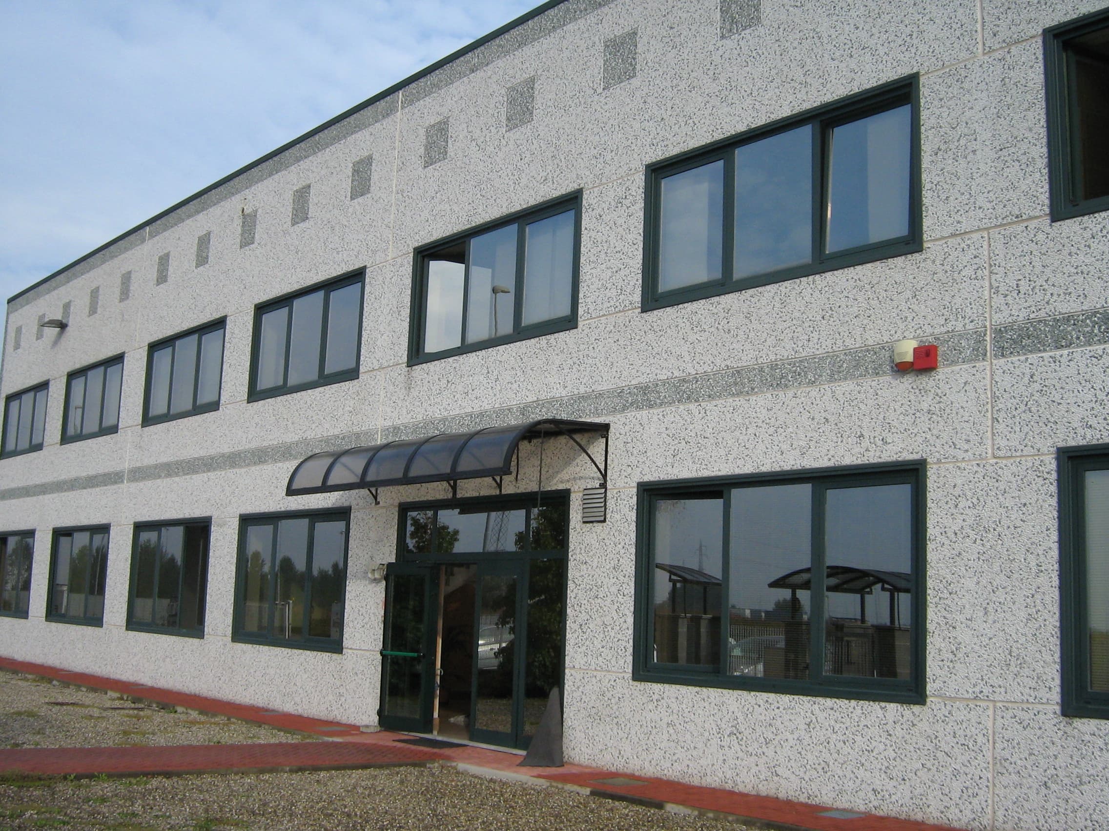 Exterior view of the DDK Italia industrial facility building with modern windows and entrance.
