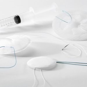 Shows a group shot of the C.A.BS'AIR Composite implants of various sizes alongside the inflation syringe on a clean white background.